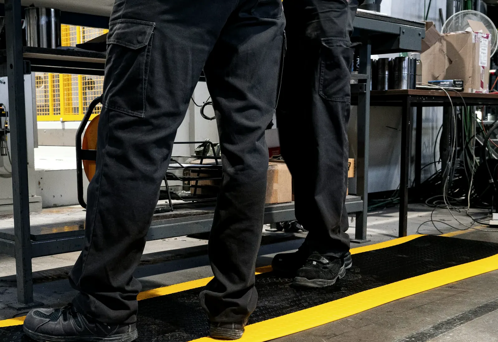 A long run of Diamond Plate matting with yellow edges beside a production line